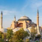 Exteriorul Sfintei Sofia din Istanbul, cu cupole mărețe, minarete subțiri și fațade istorice care redau secole de artă bizantină și otomană.