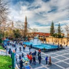 Piața Orhangazi, la poalele Marei Moschei din Bursa, este un punct de întâlnire plin de viață, înconjurat de clădiri istorice, fântâni și cafenele, inima vibrantă a atmosferei autentice a orașului.