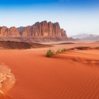 Wadi Rum, faimosul deșert roșu din Iordania, încântă prin peisaje impresionante și povestea lui Lawrence al Arabiei.