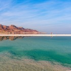 Marea Moartă, cel mai jos lac sărat de pe Pământ, cunoscută pentru apele sale hipersaline și proprietățile sale unice de vindecare pentru piele și sănătate.