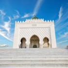 Mausoleul lui Mohammed V, o capodoperă marocană din marmură albă, adăpostește mormintele regale printre mozaicuri zellige, lemn sculptat și plafoane aurite.