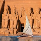 Spectaculoasa scenografie a fațadei Templului de la Abu Simbel văzută de pe o ambarcațiune cu vele în navigație pe Lacul Nasser.