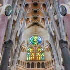 Nava Sagradei Família conduce privirea spre absidă, unde coloanele ramificate, bolțile geometrice și vitraliile policrome alcătuiesc bazilica-pădure imaginată de Gaudí.
