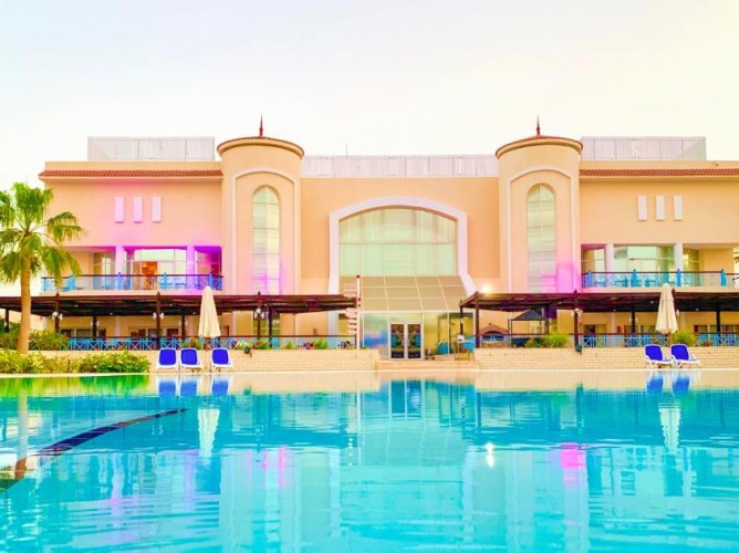 Ivy Cyrene Island Aqua Park Resort - Vederea clădirii principale cu deschidere spre piscina principală echipată cu șezlonguri și umbrele