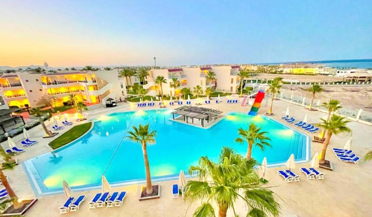 Ivy Cyrene Island Aqua Park Resort - Vedere aeriană a piscinei principale și a celor trei clădiri ale resortului, cu barul piscinei în centrul acesteia evidențiat.