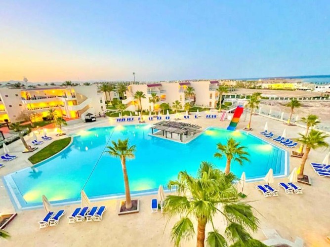 Ivy Cyrene Island Aqua Park Resort - Vedere aeriană a piscinei principale și a celor trei clădiri ale resortului, cu barul piscinei în centrul acesteia evidențiat.