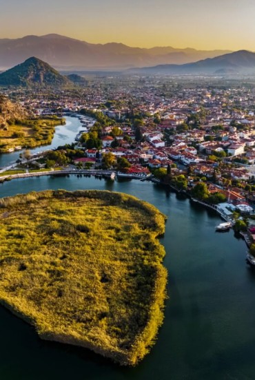 Râul Dalyan curge liniștit între munți și vegetație luxuriantă, oferind vederi spectaculoase ale mormintelor săpate în stâncă și peisaje liniștite. Navigarea acestuia este o experiență unică ce combină istoria și natura.