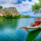 Bărcile tradiționale din lemn de pe râul Dalyan navighează încet prin vegetația luxuriantă, oferind vederi uimitoare ale mormintelor săpate în stâncă și priveliști spectaculoase ale faunei locale.