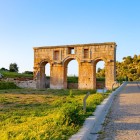 Vechiul acces al orașului Patara, cu impunătorul arc monumental roman, îi întâmpină pe vizitatori printre ruine istorice și peisaje mediteraneene, mărturie a măreției Liciei antice.