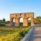 Vechiul acces al orașului Patara, cu impunătorul arc monumental roman, îi întâmpină pe vizitatori printre ruine istorice și peisaje mediteraneene, mărturie a măreției Liciei antice.