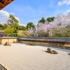 Grădina de Rocă a templului Ryoan-ji din Kyoto este o capodoperă a minimalismului zen. Compușă din 15 pietre aranjate pe nisip alb, oferă o experiență meditațională unică, simbolizând echilibrul și reflecția interioară.