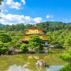 Vedere splendidă a Pavilonului de Aur (Kinkaku-ji) din Kyoto, un templu auriu înconjurat de natură, reflectat într-un iaz ce-i accentuează frumusețea și armonia peisajului japonez.