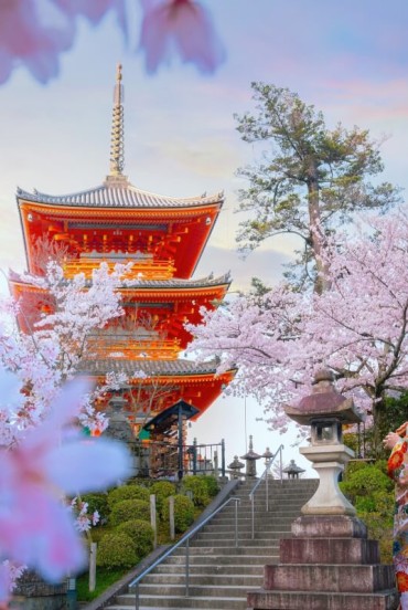 O tânără japoneză în kimono tradițional, în fața templului Kiyomizu-dera din Kyoto, întruchipează eleganța și cultura niponă, printre arhitecturi vechi și peisaje deosebite.