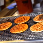 Delicioși biscuiți japonezi din orez sunt preparați la grătar pe loc, printre aromele și culorile pieței de dimineață din Takayama, unul dintre cele mai autentice locuri din Japonia tradițională.