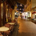 Rue Mouffetard noaptea, una dintre cele mai vechi străduțe pavate din Paris, târziu în noapte cu o piață de fructe și o cafenea încă deschise.