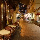 Rue Mouffetard noaptea, una dintre cele mai vechi străduțe pavate din Paris, târziu în noapte cu o piață de fructe și o cafenea încă deschise.