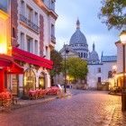 Dimineata, Place du Tertre din Montmartre prinde viata cu mese de cafenea si artisti pregatindu-si panzele, iar Bazilica Sacré-Cœur domina orizontul parizian.
