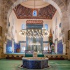 Interiorul Moscheii Verzi din Bursa este o explozie de artă și culoare, cu plăci ceramice turcoaz și verde, motive islamice complicate și caligrafie care creează o atmosferă sacră și sugestivă.