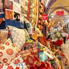 Țesături, perne, covoare, kilimuri și eșarfe în culori vii la Marele Bazar din Istanbul, unde arta și cultura se împletesc în creații unice.