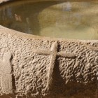 Fântână baptismală antică la situl Al-Maghtas, Iordania, locul tradițional al botezului lui Isus, înconjurat de ruine și monumente istorice.