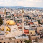 Priveliște uluitoare asupra Moscheii din Madaba, cu orașul desfășurându-se în fundal printre lumini, culori și o istorie milenară.