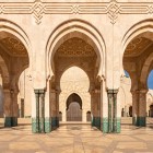 Arcurile exterioare ale Moscheii Hassan II afișează mozaicuri complicate și motive islamice, o expresie a artei marocane și a măiestriei meșteșugărești fără egal.