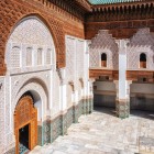 Pereții curții Medresei Ben Youssef prezintă plăci zellige multicolore în partea de jos și sculpturi în stuc deasupra, cu ferestre din lemn sculptat manual.