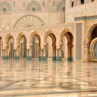 Exteriorul Moscheii Hassan II încântă prin arcade elegante și fântâni care reflectă arta islamică, creând o atmosferă de pace și măreție lângă mare.