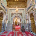 Interioarele Moscheei Moulay Idriss din Fes sunt bogate în mozaicuri colorate și detalii rafinate, care evidențiază tradiția artistică și spirituală marocană.
