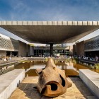 La intrarea muzeului, o statuie monolitică teotihuacană introduce comorile din interior, simbol al armoniei dintre ancestralitate și modernitate în Ciudad de México.