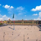 Fațada Palatului Național domină centrul Zócalo-ului din Ciudad de México, iar în stânga se înalță un turn al Catedralei, simbol al istoriei și identității.