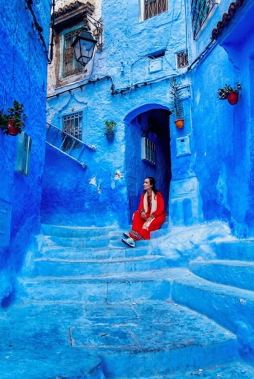 Străduță albastră în pantă la Chefchaouen: pereți vopsiți, uși colorate și o atmosferă magică pe aleile orașului cel mai fermecător din Maroc.