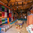 În souk-ul din Aït Ben Haddou, tarabele vând produse artizanale locale, inclusiv covoare berbere, ceramică colorată, țesături și obiecte tradiționale realizate manual.