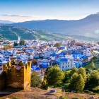 Chefchaouen văzut de sus dezvăluie un mozaic de case turcoaz încadrate între munți, un sat unic care încântă prin culorile sale și atmosfera magică a Marocului.