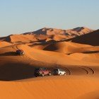 Safari cu 4x4 la răsărit pe dunele din Merzouga, când deșertul se colorează în aur și roz, oferind emoții unice între nisip și lumină.