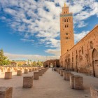 Minaretul Moscheii Koutoubia din Marrakech se înalță deasupra medinei, cu decorațiuni în stil almohad și o formă iconică vizibilă de la distanță.