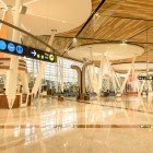 Interioare luminoase ale aeroportului Marrakech Menara cu acces eficient la porți, zone de relaxare, magazine duty-free și servicii moderne pentru călători.
