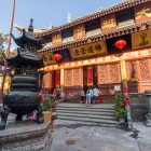 Exterior tradițional al Templului Budha de Jad din Shanghai, cu arhitectură clasică, decorațiuni din lemn și o atmosferă spirituală autentică.