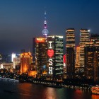 Vedere nocturnă a orașului Shanghai, cu zgârie-nori iluminați, Bund-ul și luminile orașului reflectând modernitatea și istoria metropolei chineze.