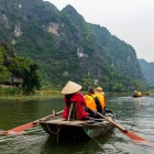 Un tur cu barca în Tam Cốc străbate râuri liniștite printre câmpuri de orez și munți carstici, oferind priveliști pitorești ale naturii vietnameze.