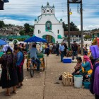 Piața din fața Bisericii Sfântul Ioan Botezătorul este un mozaic viu de culori, tarabe, fructe, artizani și femei indigene, unde tradițiile maya și farmecul colonial se întâlnesc.