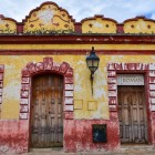 Un magazin de pantofi în stil colonial, tipic pentru San Cristóbal, cu o fațadă galben-ocru și detalii roșii erodate de timp, care redau farmecul autentic al acestui oraș din Chiapas.