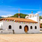 Biserica San Lorenzo din Zinacantán, Chiapas, impresionează prin fațada sa albă și detaliile colorate, fiind centrul spiritual al comunității tzotzil și un simbol al tradițiilor indigene.