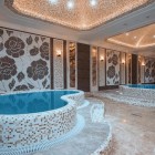 Zonă wellness elegantă cu piscine jacuzzi, mozaicuri decorative și iluminare discretă. Un ambient rafinat și relaxant, ideal pentru momente de relaxare și confort exclusiv.