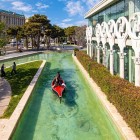 Priveliște urbană sugestivă din Baku cu canal artificial, barcă turistică și arhitectură elegantă. Un colț modern între verdeață, apă și o atmosferă relaxantă.