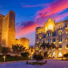 Orașul Vechi din Baku la apus încântă prin zidurile medievale iluminate și clădirile elegante, îmbinând istoria antică cu farmecul modern în inima Icherisheher.