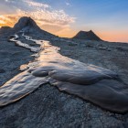 Vulcanii noroioși din Gobustan, lângă Baku, creează peisaje spectaculoase cu scurgeri de argilă și reliefuri gri: un fenomen natural unic și fascinant al Azerbaidjanului.