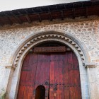 Portalul din lemn al Caravanseraiului din Sheki, cu arc din piatră decorat, reflectă arhitectura Drumului Mătăsii, între eleganță și funcționalitate.