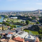 Panoramă asupra orașului Tbilisi cu râul Kura, poduri moderne și biserici istorice pe coline: un amestec armonios între arhitectură veche și contemporană.