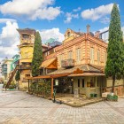 În cartierul vechi din Tbilisi, casele din lemn, balcoanele sculptate și un turn cu ceas creează o atmosferă de poveste printre străzi pavate și cafenele istorice.